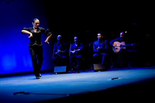 Vestida todavía de negro baila ahora con el grupo al fondo en la imagen