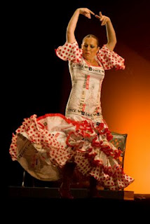 Con los brazos arqueados ya luciendo el vestido de los cupones en un gesto muy flamenco