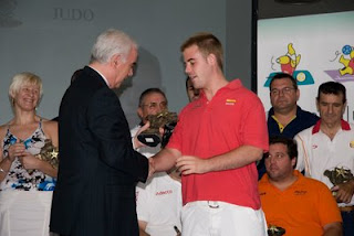 El consejero de Turismo, Comercio y Deportes de la Junta entrega un trofeo al judoka sevillano Abel Vázquez