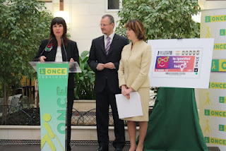 Micaela Navarro durante su intervención en la presentación del cupón dedicado al Día Internacional de la Mujer junto a Patricio Cárceles y la directora del Centro de Recursos Educativos de la ONCE en Sevilla, Amparo Cruz