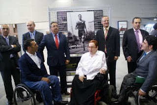 Los asistentes a la presentación posan junto a una de los cuadros expuestos