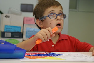Un alumno sordociego durante una de sus clases pintando un folio