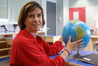 La directora del CRE coge entre sus manos una bola del mundo que utilizan los alumnos en sus clases