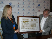 La nueva directora de la ONCE en Córdoba, Estela medina, y el alcalde de la ciudad, Andrés Ocaña, posan con la copia de la plancha que ha dado origen al cupón