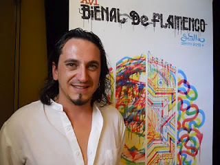 Primer plano de Antonio Mejías con el fondo del cartel oficial de la Bienal de Flamenco