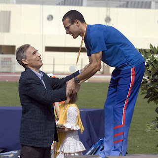 El director de la ONCE en Huelva, Antonio Casado, entregando una de las medallas a los atletas