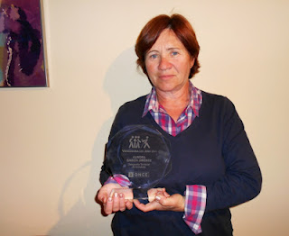 Aurora García, vendedora del año en Sevilla, sostiene la placa conmemorativa