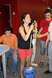 Una chica se desenvuelve con objetos de limpieza diarios como el cubo y la fregona