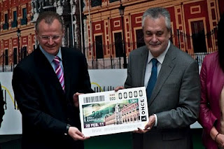 El representante de la ONCE en Andalucía, Patricio Cárceles, entregando un azulejo conmemorativo con la imagen del cupón del día 28 de febrero al presidente de la Junta de Andalucía, José Antonio Griñán