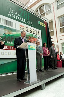 Patricio Cárceles, representante de la ONCE, durante su intervención en el acto con la imagen del cupón de fondo