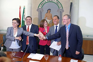 Foto de familia de los firmantes juntando sus manos