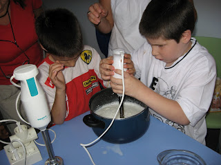 Dos alumnos amasan con la batidora una crema para un bizcocho