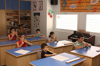 Los alumnos de música tocando sus flautas en el aula