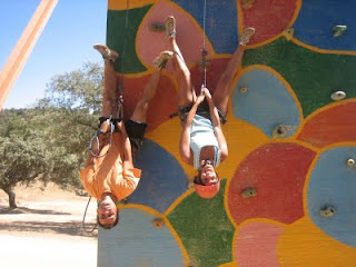 Simpática imágen de dos jóvenes boca abajo bajando del rocódromo sujetados a las cuerdas