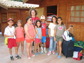 Rosa, la coordinadora de los monitores de Sevilla, posa con los más pequeños a las puertas de la cabaña