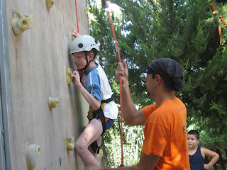 Un niño en plena subida al rocódromo, una de las actividades estrella del campamento de El Bosque
