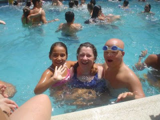 Rosa, la coordinadora de los monitores en la piscina con dos jóvenes encantados de bañarse