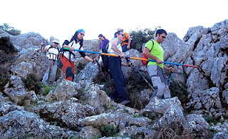 Marchistas descendiendo por unas escarpadas rocas