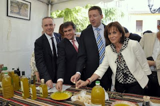 Cristóbal Martínez, director de la ONCE en Málaga, probando el aceite típico de Periana junto a otros asistentes al acto