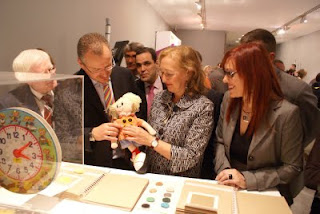 La presidenta del Parlamento sostiene en sus manos a Braillín entre sonirsas del delegado territorial y la presidenta del Consejo