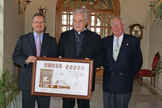 El cardenal de Sevilla sostiene la copia de la plancha del cupón de Monte-Sión junto al delegado territorial y el hermano mayor