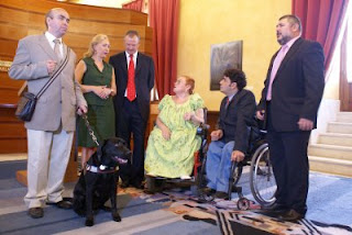 La presidenta del Parlamento conversa con el delegado territorial de la ONCE y el presidente del Consejo, junto a la presidenta del CERMI y el director de Coria del Río con su perro guía