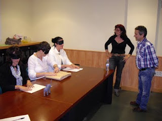 Profesores asistentes al curso con un atifaz en los ojos simulando la ceguera total, y palpando varios objetos