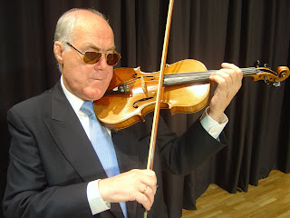 Francisco Somoza posa con su violín sobre el escenario del salón de actos de la Delegación Territorial