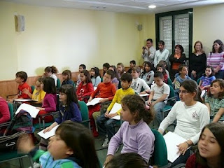 El salón de actos lleno de alumnos atentos a la presentación del libro