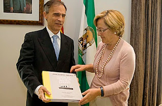 El director de la ONCE en Huelva con la presidenta de la Diputación mostrando el ejemplar en braille