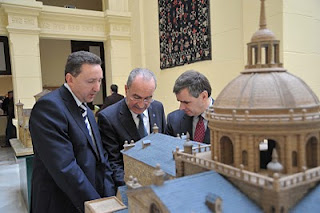 El alcalde de Málaga tocando la maqueta de la iglesia palentina