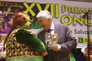 El delegado de la Junta entrega sonriente el primer premio a la chirigota Las Muchachas del Congelao