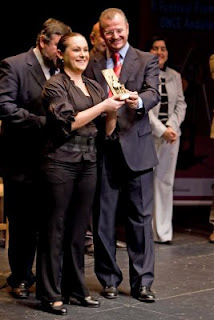 Una MariÁngeles Narváez muy sonriente recibe el premio de manos del Delegado Territorial de la ONCE en Andalucía