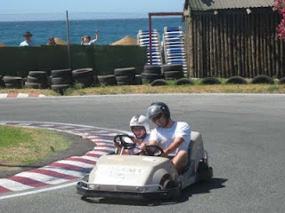 Un chico disfruta de una carrera de carts junto a uno de los monitores