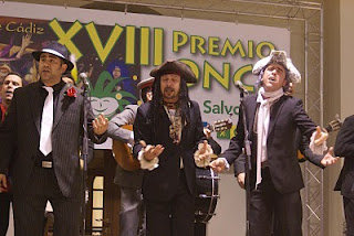 Tres de los protagonistas de la comparsa G-15 en plena actuación, con ojos cerrados y brazos abiertos