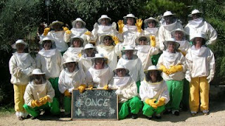 Foto de familia de los visitantes de la granja vestidos de apicultores