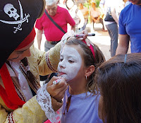Una animador pinta la cara a una niña durante la celebración del Día de la ONCE en Cádiz