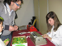 Una monitora creando el nombre de un niño en braille