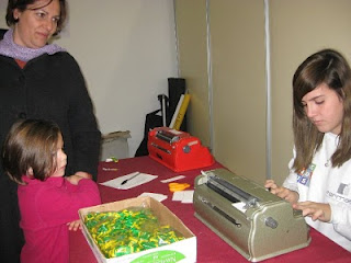 una de las monitoras de juveandalus escribe en una máquina de braille el nombre de una niña