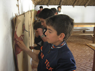Los niños visten el mural de pintura rupestre con sus pinceles