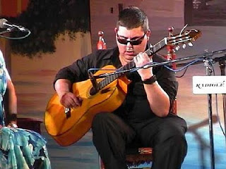 Juan Miguel Ramos Acevedo, 'El plazoleta'. Guitarrista flamenco, afiliado de la ONCE, sobre un escenario, tocando su guitarra