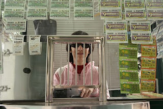 Imagen de una vendedora en su kiosco de la ONCE con el producto expuesto