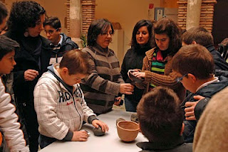 Un grupo de niños observando y tocando las piezas expuestas sobre una mesa