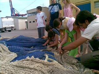 Los jóvenes, todos apelotonados, comprueban la solidez de las redes de pesca