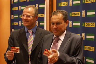 El delegado territorial y el subdelegado muestran a las cámaras la imagen del pen drive que contiene los datos de la Memoria de la ONCE de 2009