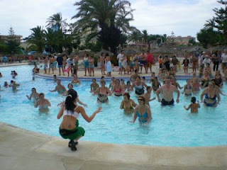 Decenas de personas en el agua, esperando las indicaciones de la animadora