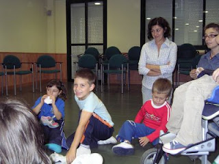Niños, madres y monitores, sonrientes en medio de la clase