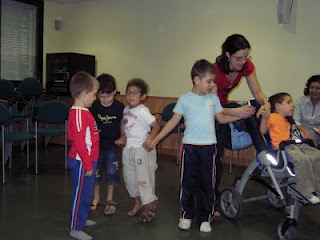 Varios niños atienden las explicaciones de su monitora