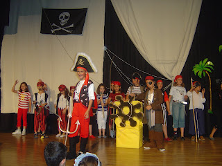 Imagen de la representación de la isla del tesoro, con todos los jóvenes actores vestidos de piratas