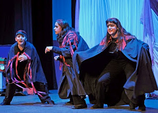 Tres actores con sus capas abiertas sobre el escenario